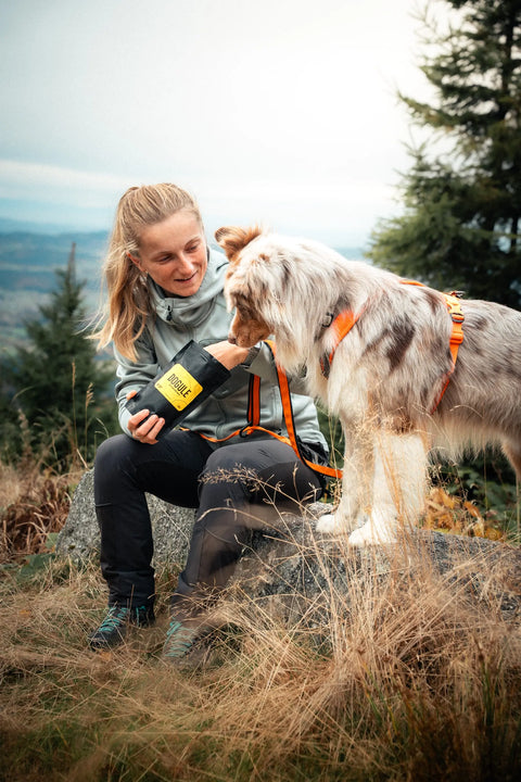 Psí trenérka na výšlapu se svým psem australským ovčáke, dávající Dogule jako odměnu
